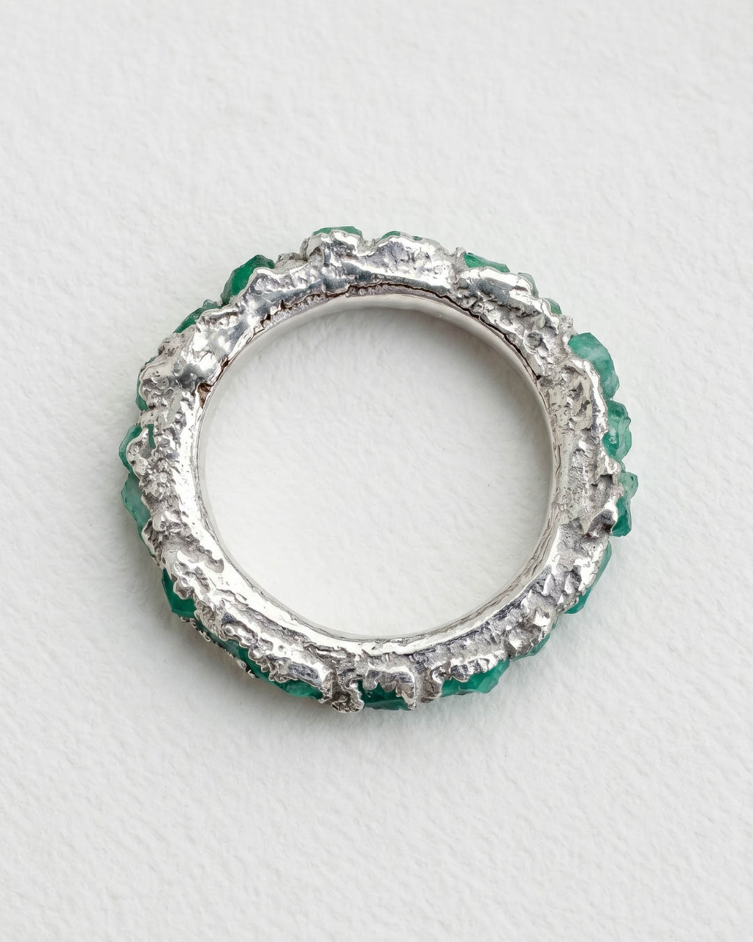 Infinity ring in 925 silver with emerald fusion.